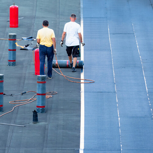 commercial flat roofing being applied by roofers